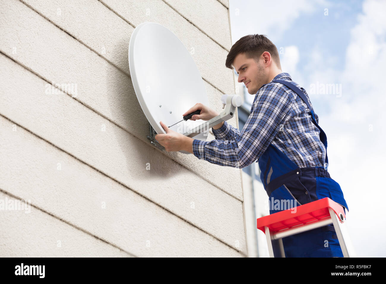 Technician Installing TV Satellite Dish On Wall Stock Photo Alamy