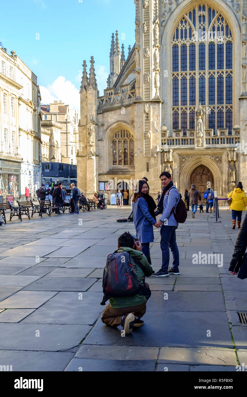 Visitors having their picture taken in front of bath abbey. A winters day in Bath city Center, somerset england UK Stock Photo
