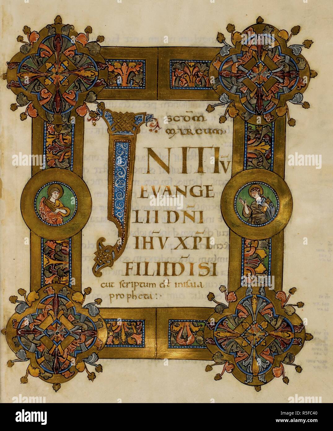 Initial 'I'(nitium) with interlace decoration and display script in gold, framed by a 'Winchester style' foliate border with two medallions with saints holding books (Evangelists?), at the beginning of Mark. Gospels (the 'Cnut Gospels'). England, S. E. (Christ Church, Canterbury); 1st quarter of the 11th century (c. 1020). Source: Royal 1 D. IX, f.45. Language: Latin. Stock Photo