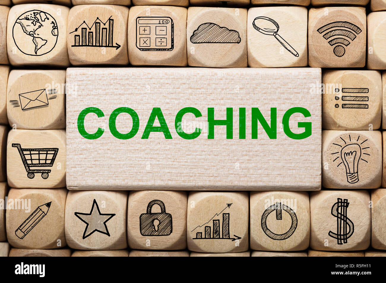 Coaching Text On Wooden Block Surrounded By Computer Icons Stock Photo