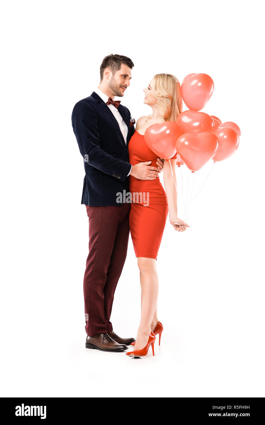 Hugging Balloons Beautiful smiling couple hugging while holding red balloons isolated on ...