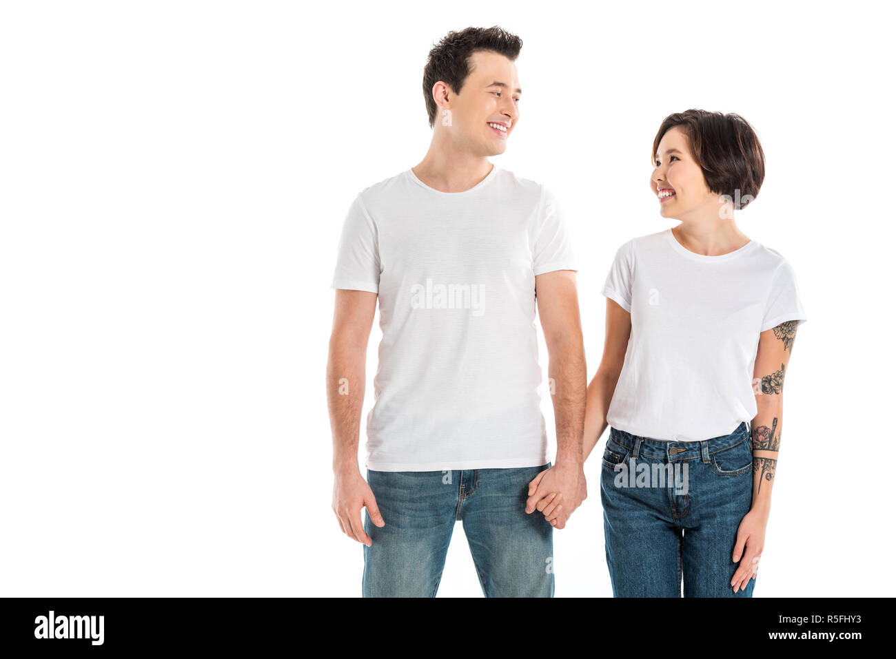 happy couple holding hands and looking at each other isolated on white ...
