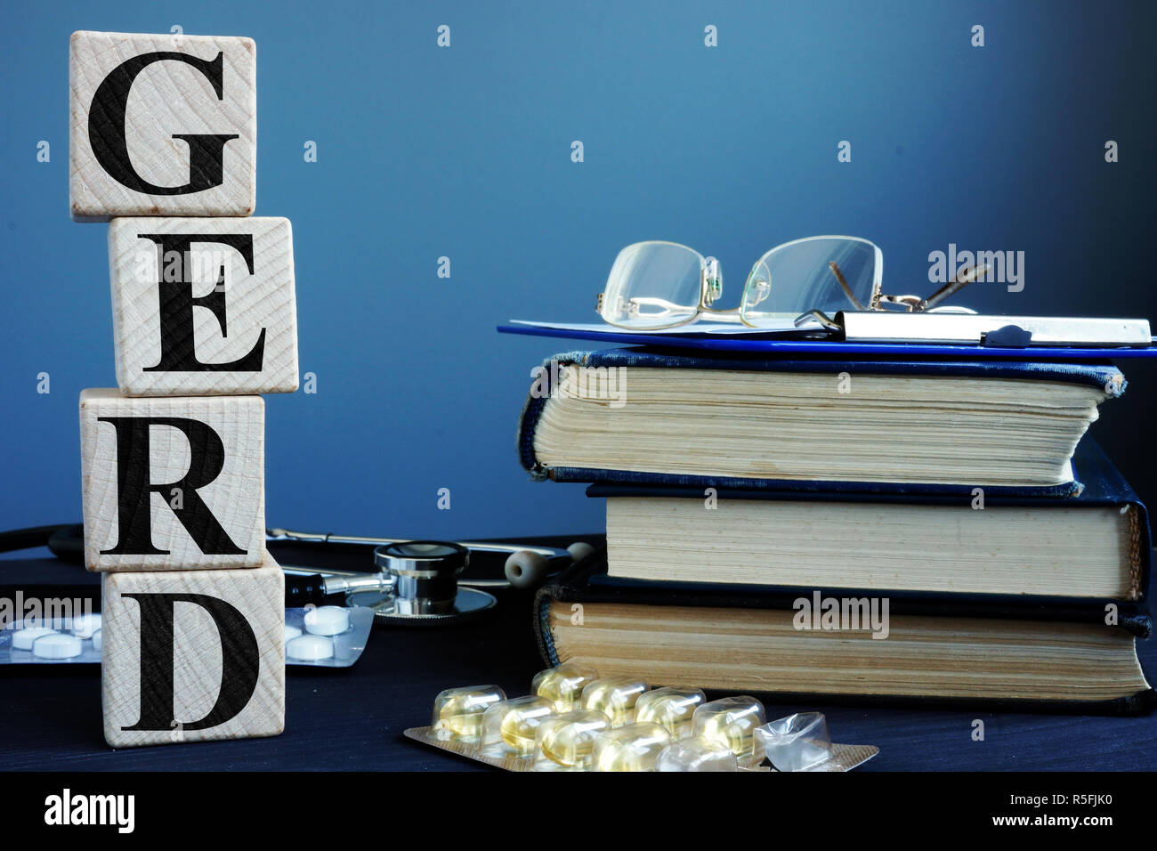 Word GERD Gastroesophageal reflux disease from cubes and books. Stock Photo