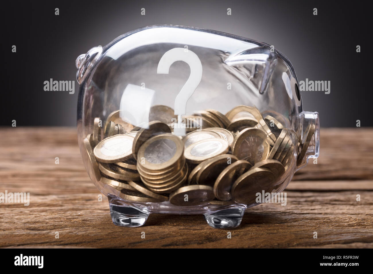 Question Mark And Coins In Transparent Piggy Bank Stock Photo