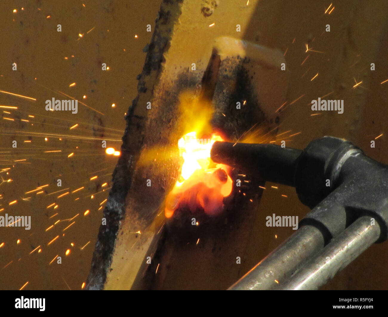 Hot Sparks of fire from steel cutting machines when men are using the grinder disc to cut steel or the oxygen weld to weld steel parts together Stock Photo