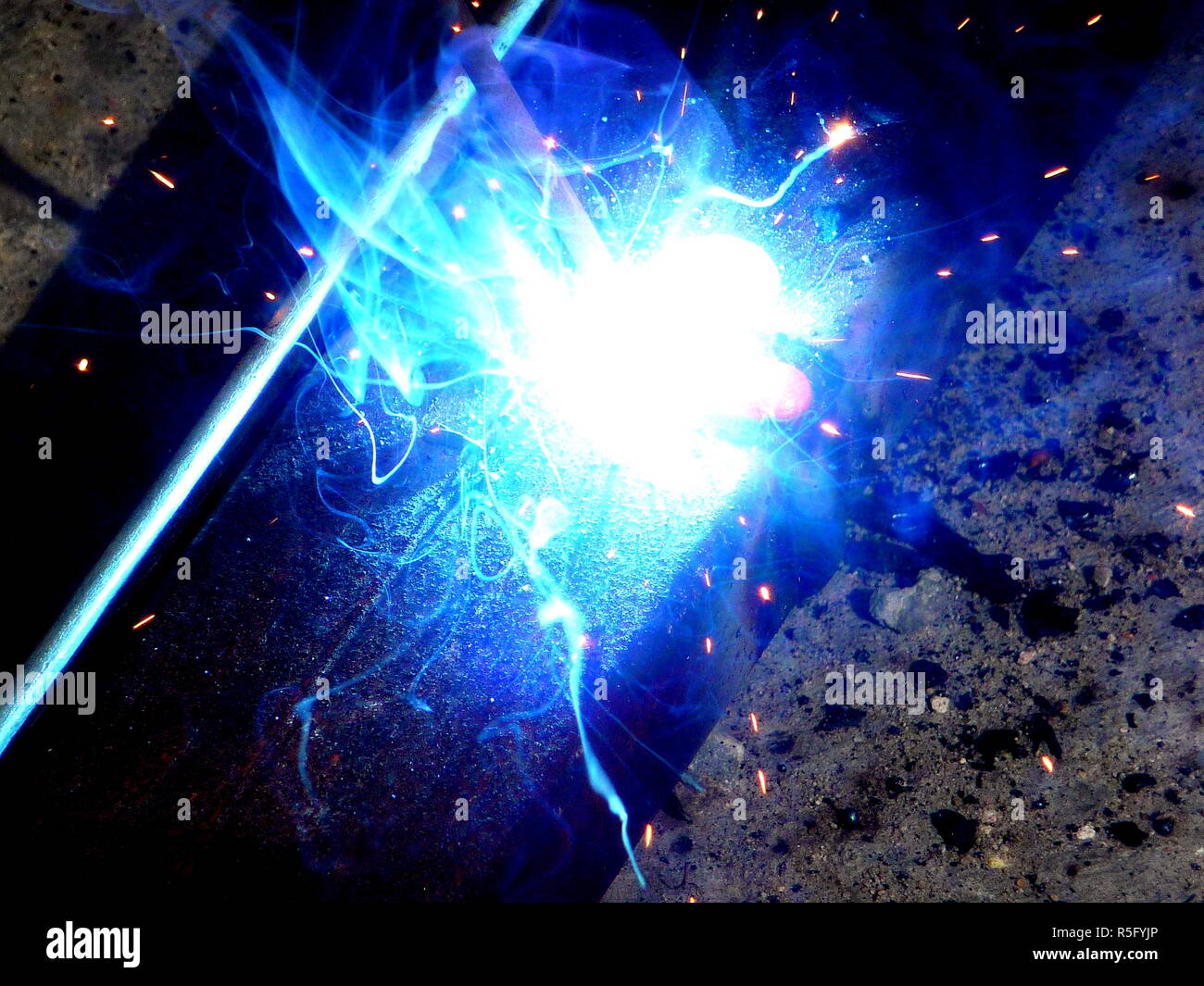 Hot Sparks of fire from steel cutting machines when men are using the