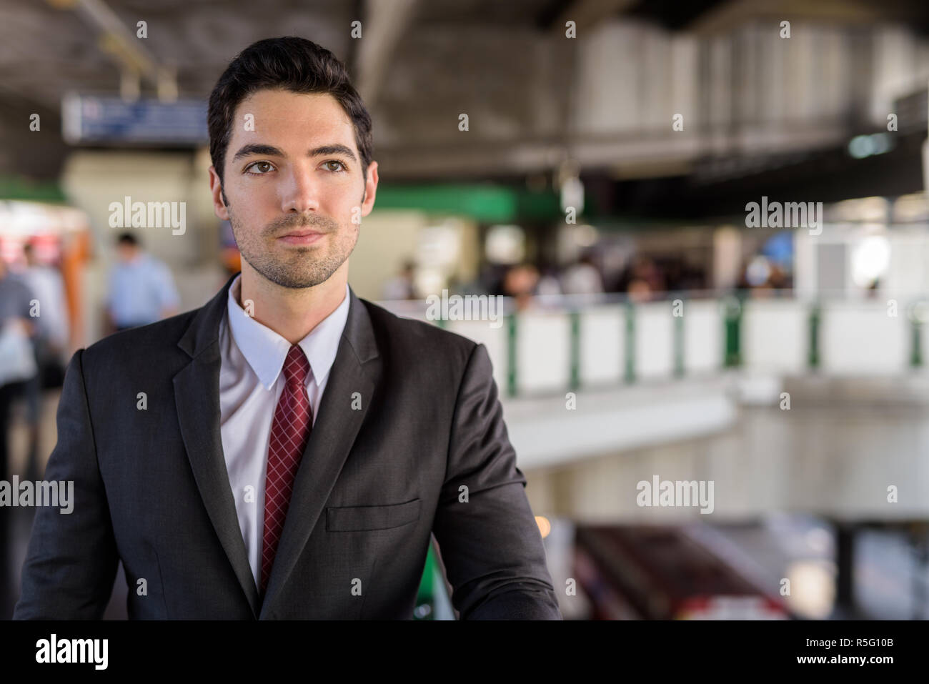 Portrait of young handsome businessman wearing suit in city Stock Photo ...