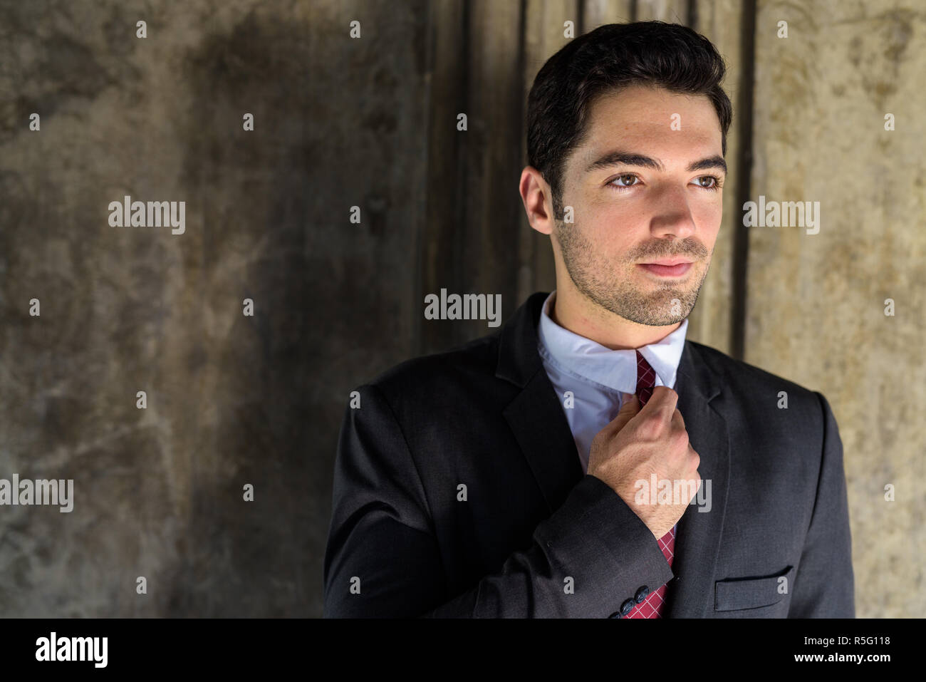 Portrait of young handsome businessman wearing suit in city Stock Photo ...