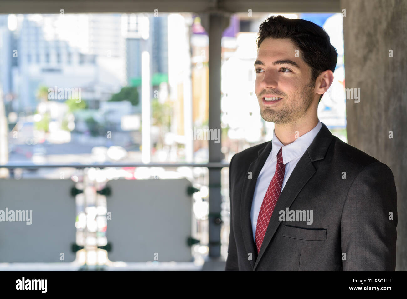 Portrait of young handsome businessman wearing suit in city Stock Photo ...