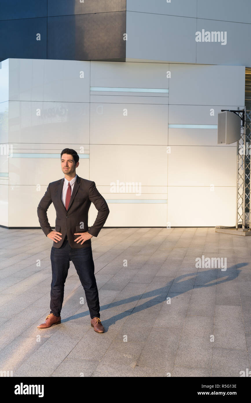 Portrait of young handsome businessman wearing suit in city Stock Photo ...