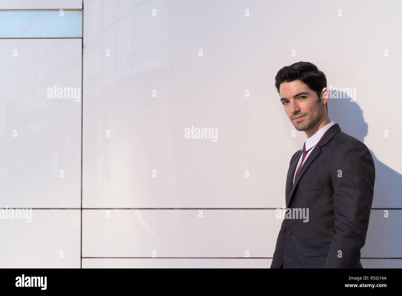 Portrait of young handsome businessman wearing suit in city Stock Photo ...
