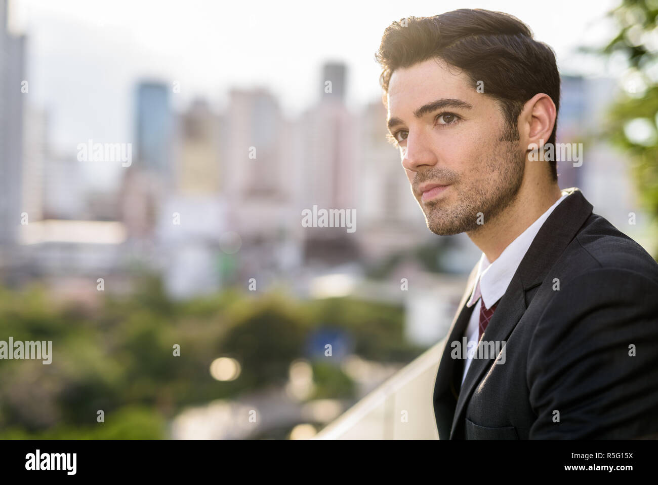 Portrait of young handsome businessman wearing suit in city Stock Photo ...