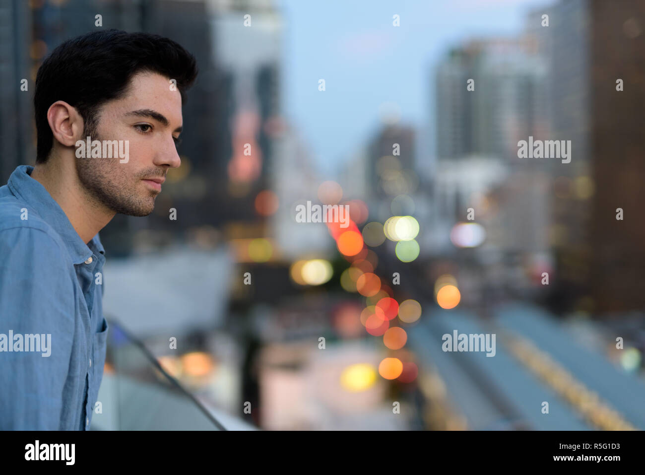 Portrait of young handsome man outdoors at night in city Stock Photo