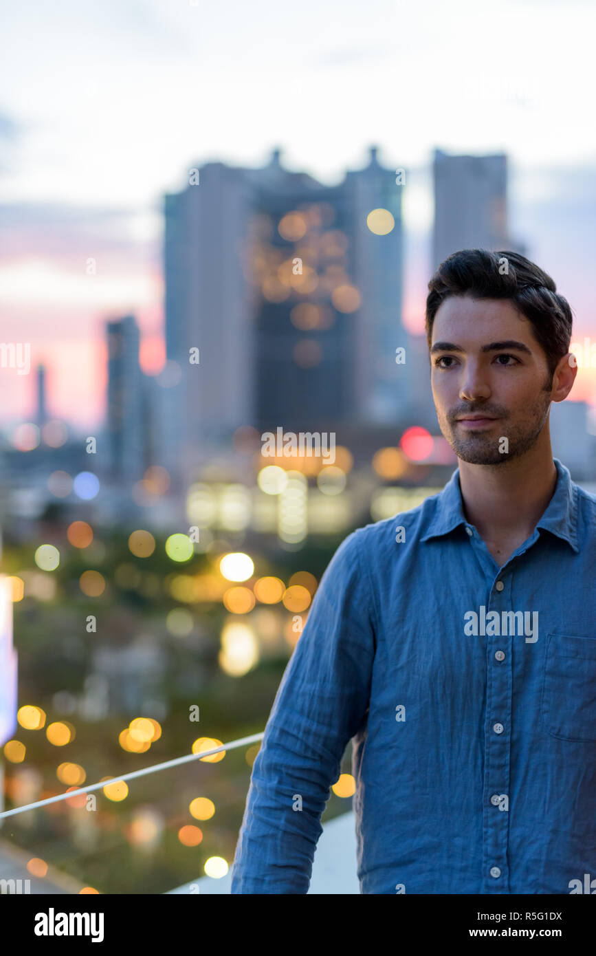 Portrait of young handsome man outdoors at night in city Stock Photo