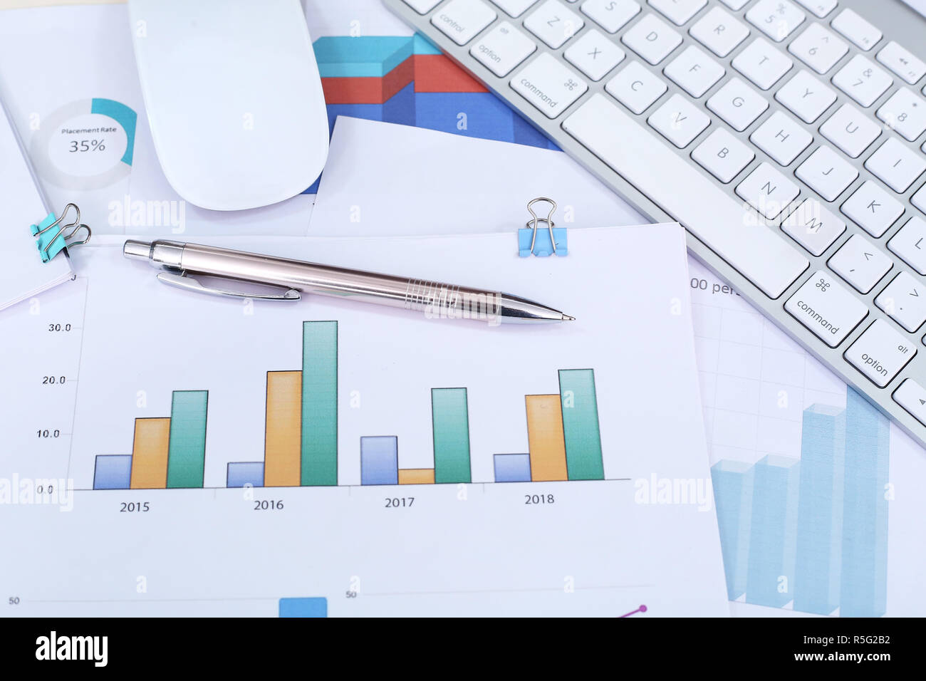 Financial chart paper, pen, keyboard and mouse. Stock Photo