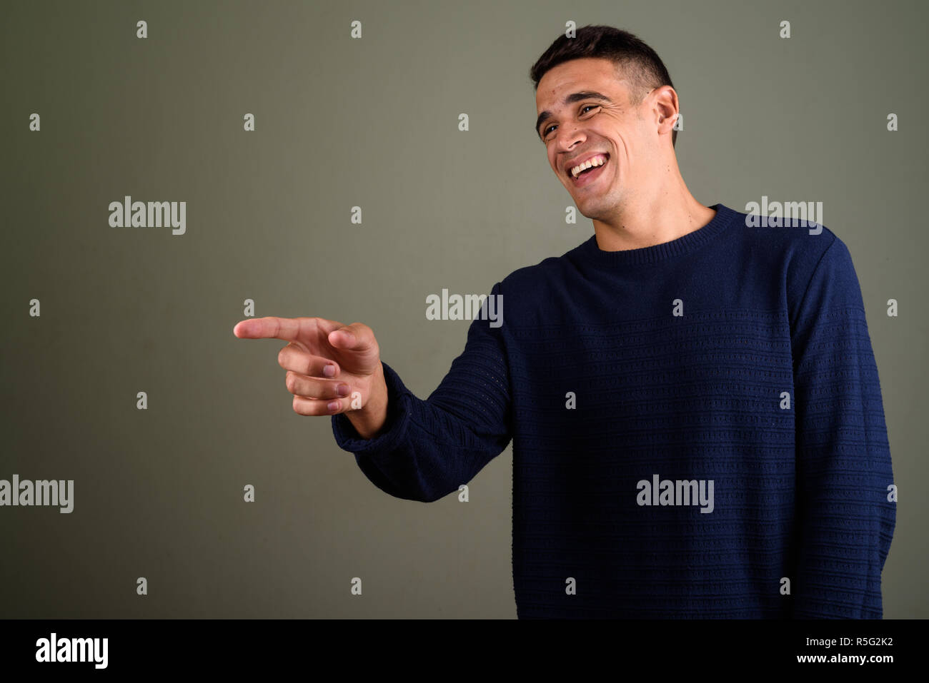 Young handsome man wearing sweater against colored background Stock Photo