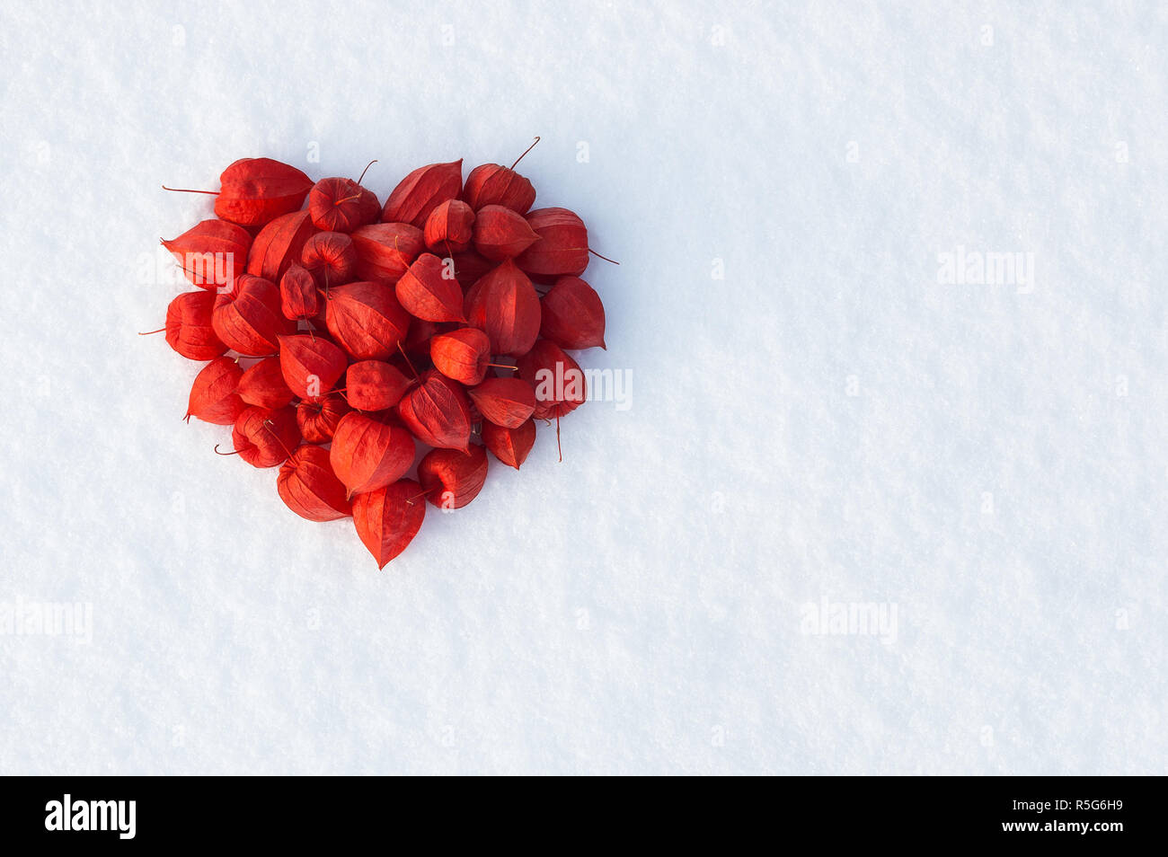 Valentine card with red heart on snow. Festive background with copy space for greeting text Stock Photo