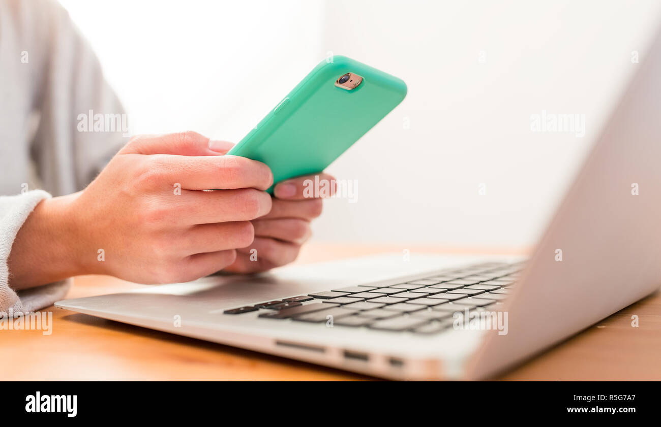 Using cellphone and laptop computer Stock Photo - Alamy