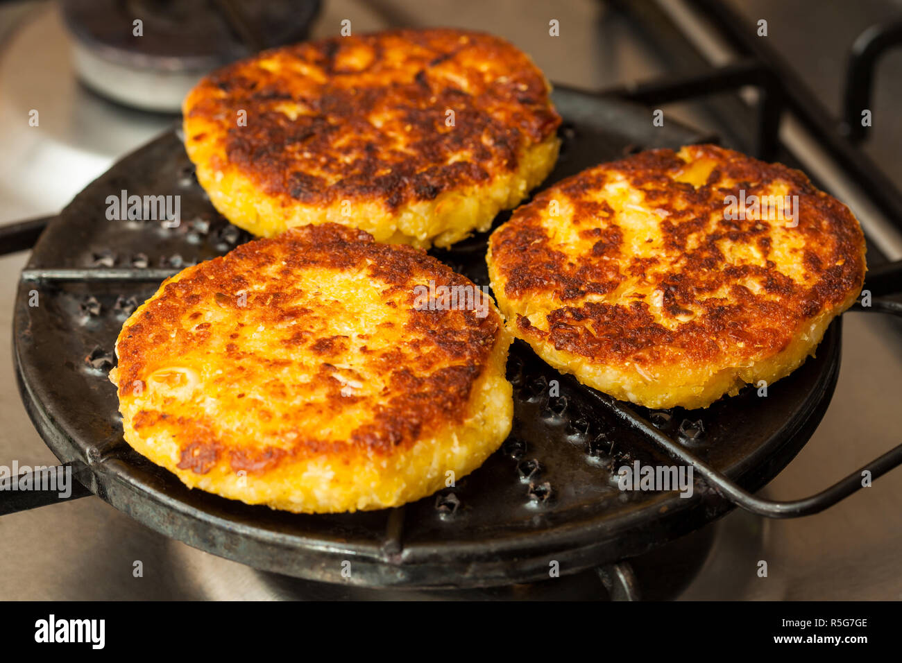 Corn breads being roasted on a round grill Stock Photo