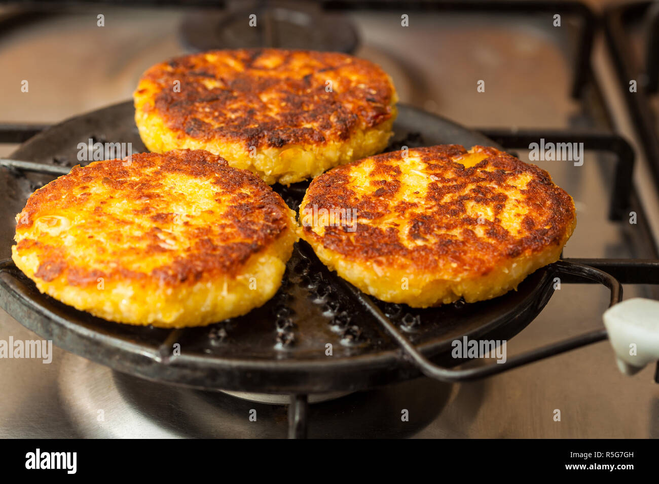 Corn breads being roasted on a round grill Stock Photo