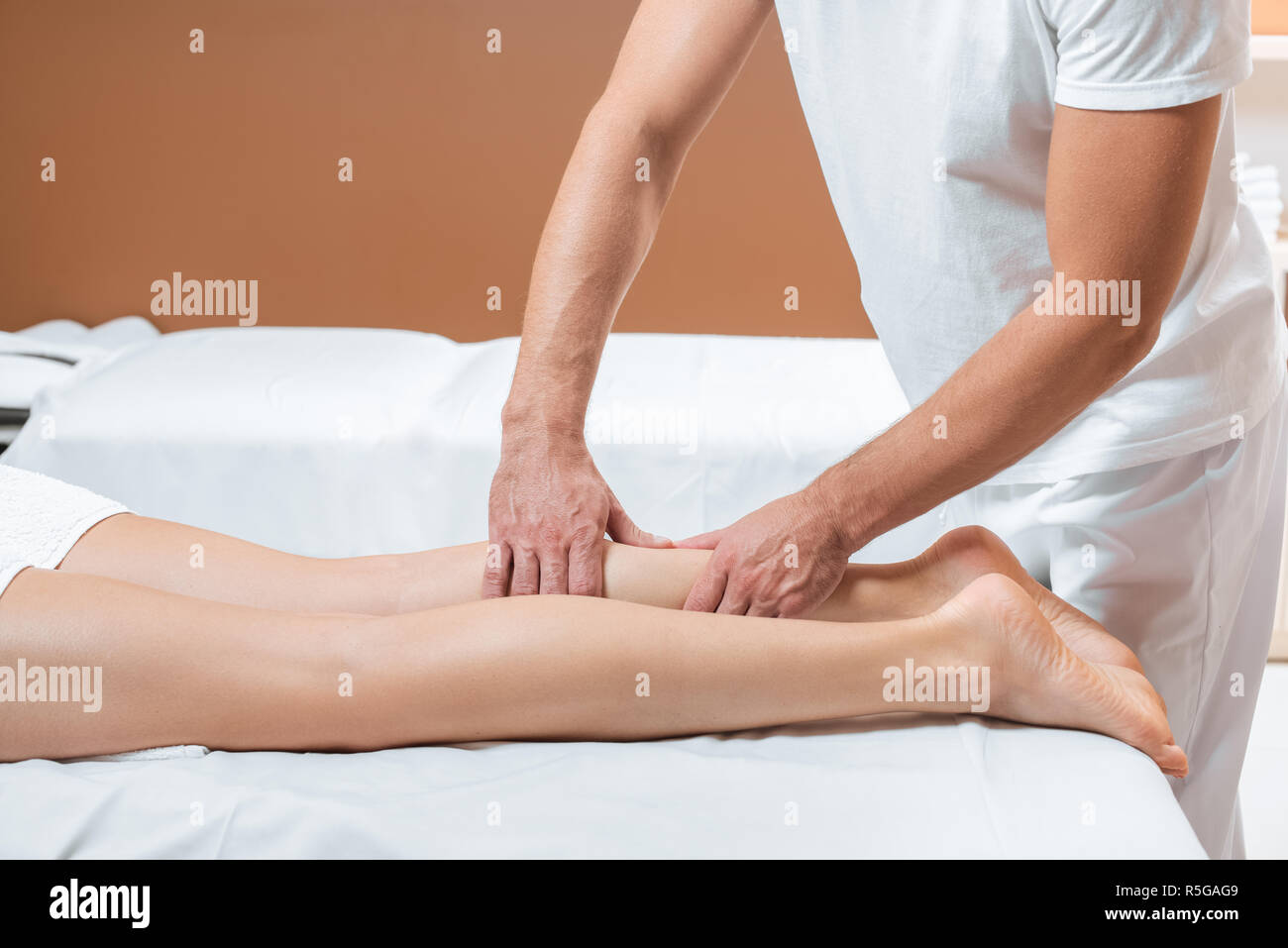 cropped view of man massaging woman legs in spa Stock Photo - Alamy