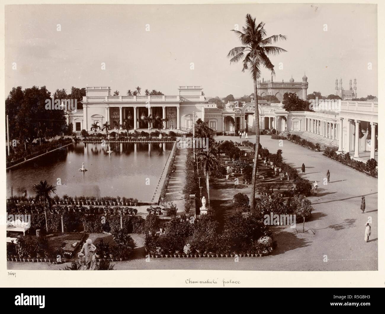Chow-mahela palace [Hyderabad]. A view looking across the garden and tank towards one of the buildings of the Chaumahalla Palace, with the Char Minar in the right background. Curzon Collection: 'Souvenir of the Visit of H.E. Lord Curzon of Kedleston Viceroy of India to H.H. the Nizam's Dominions April 1902'. c. 1902. Photograph. Source: Photo 430/33(41). Language: English. Author: Dayal, Deen. Stock Photo