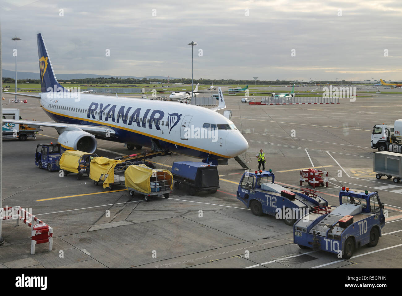 A Ryanair Boeing 737 parks on the apron at Dublin International Airport, Ireland, Terminal 2. Shows baggage loading and service vehicles. Stock Photo