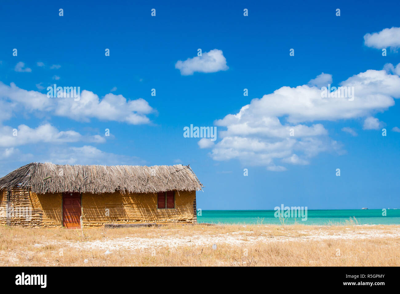 Colorful adobe house next to the sea under blue sky Stock Photo