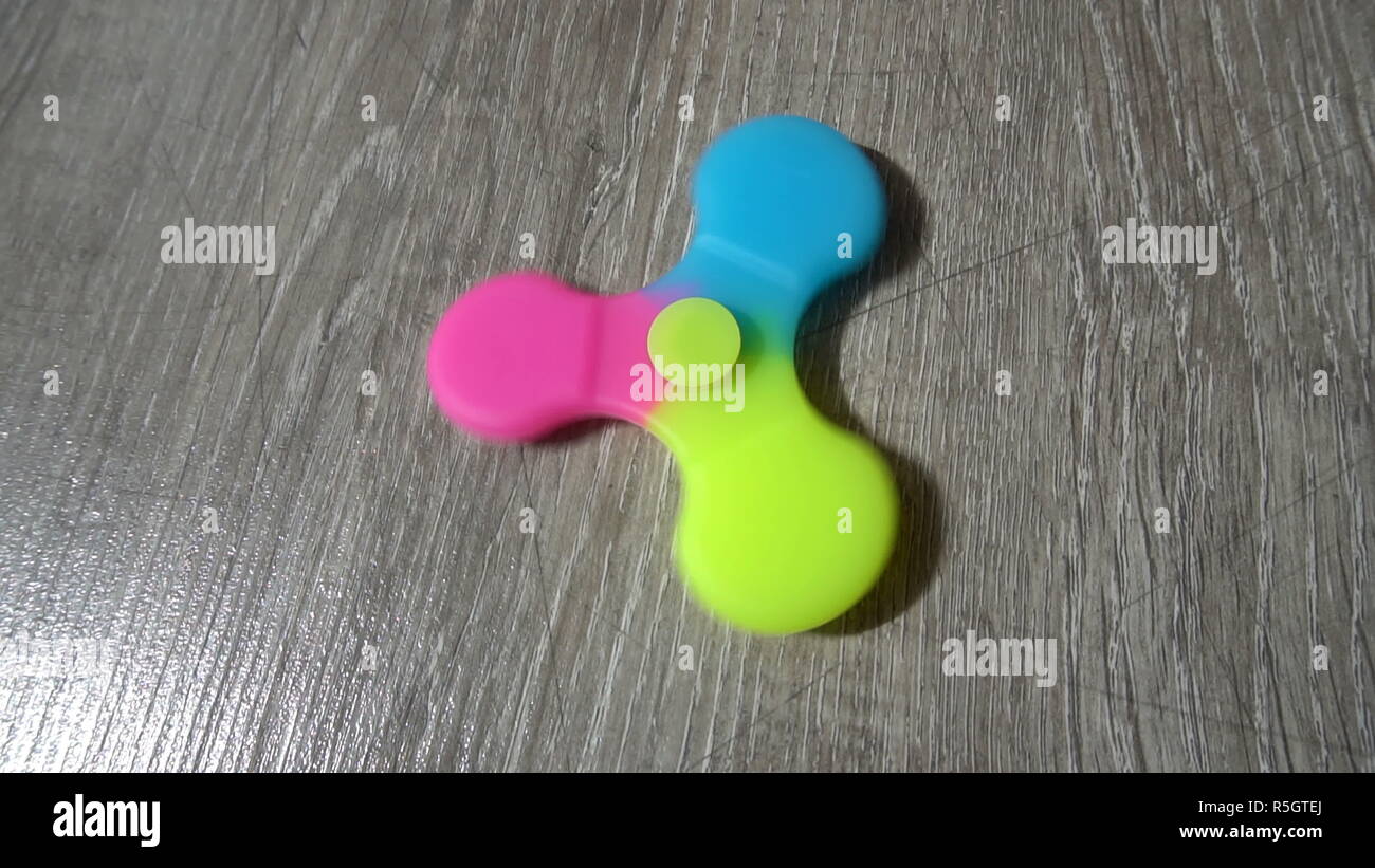 Playing with the colorful Fidget Spinner. Toy spinner Stock Photo
