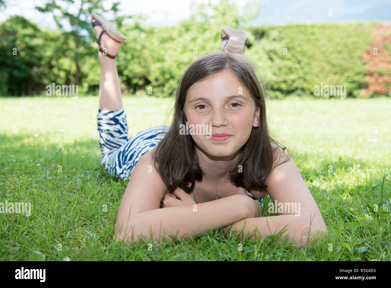 pretty pre teen girl lying in grass Stock Photo - Alamy