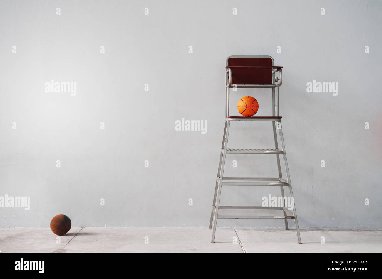 chair of sport referee with orange basketball in indoor gymnasium gray