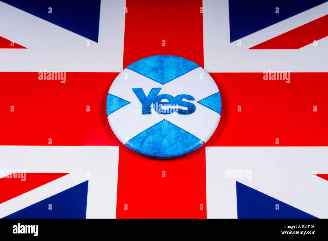 London, UK - November 18th 2018: A pin badge portraying the Scottish flag and a Yes Vote for the Scottish Independence Referendum, pictured over a UK  Stock Photo