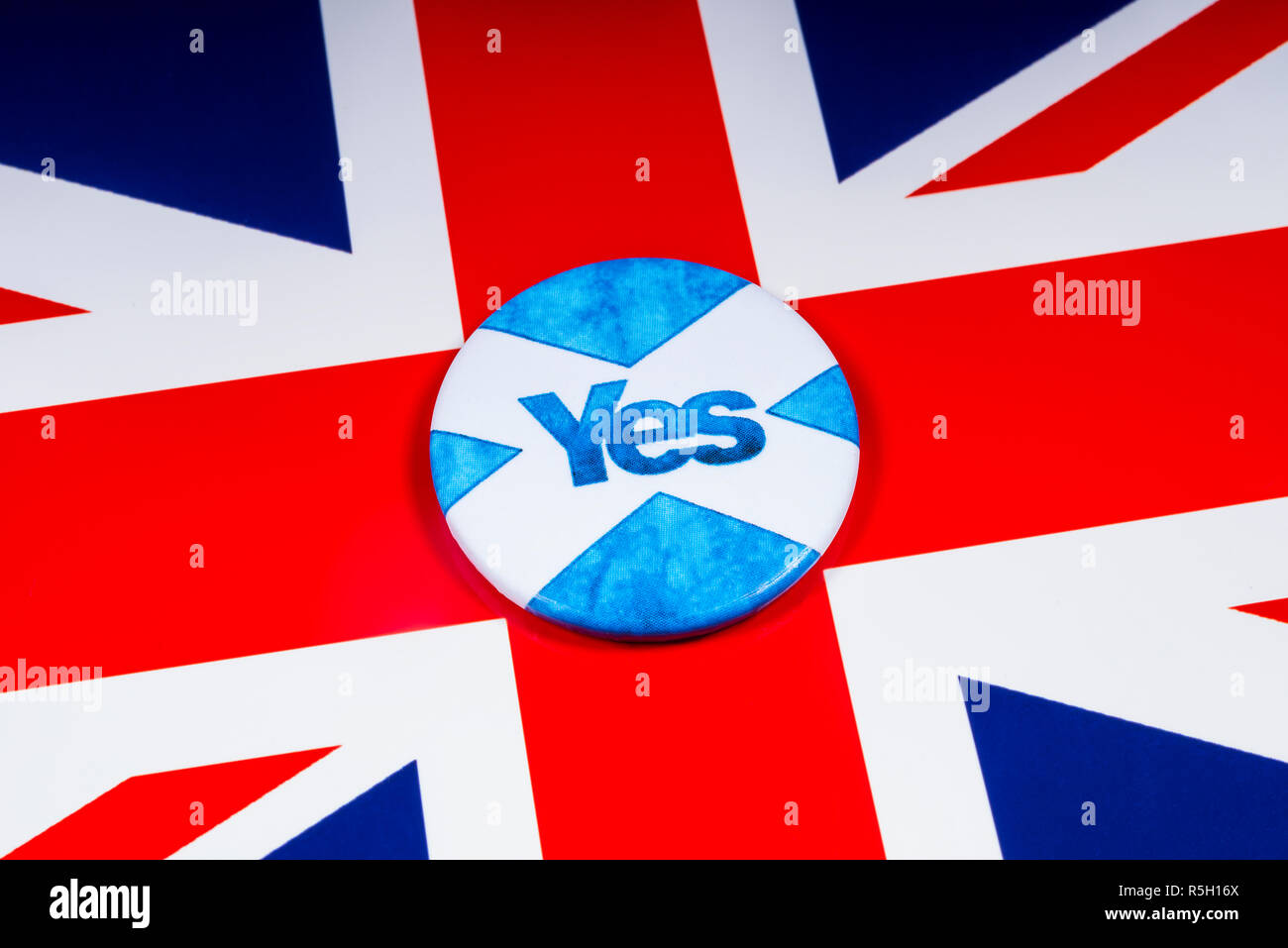 London, UK - November 18th 2018: A pin badge portraying the Scottish flag and a Yes Vote for the Scottish Independence Referendum, pictured over a UK  Stock Photo