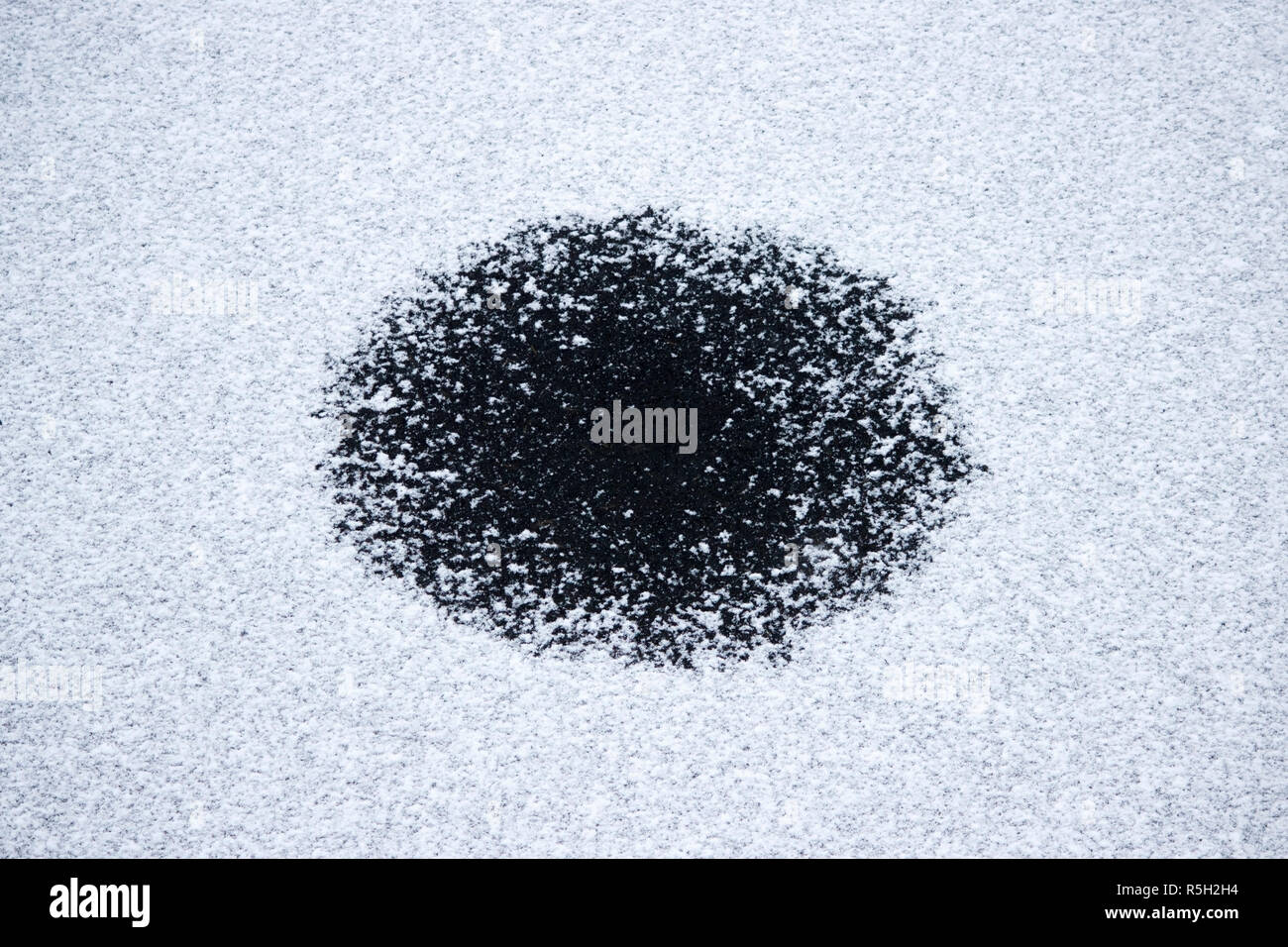 round small hole in thin ice on a lake in the Gatchina park Stock Photo