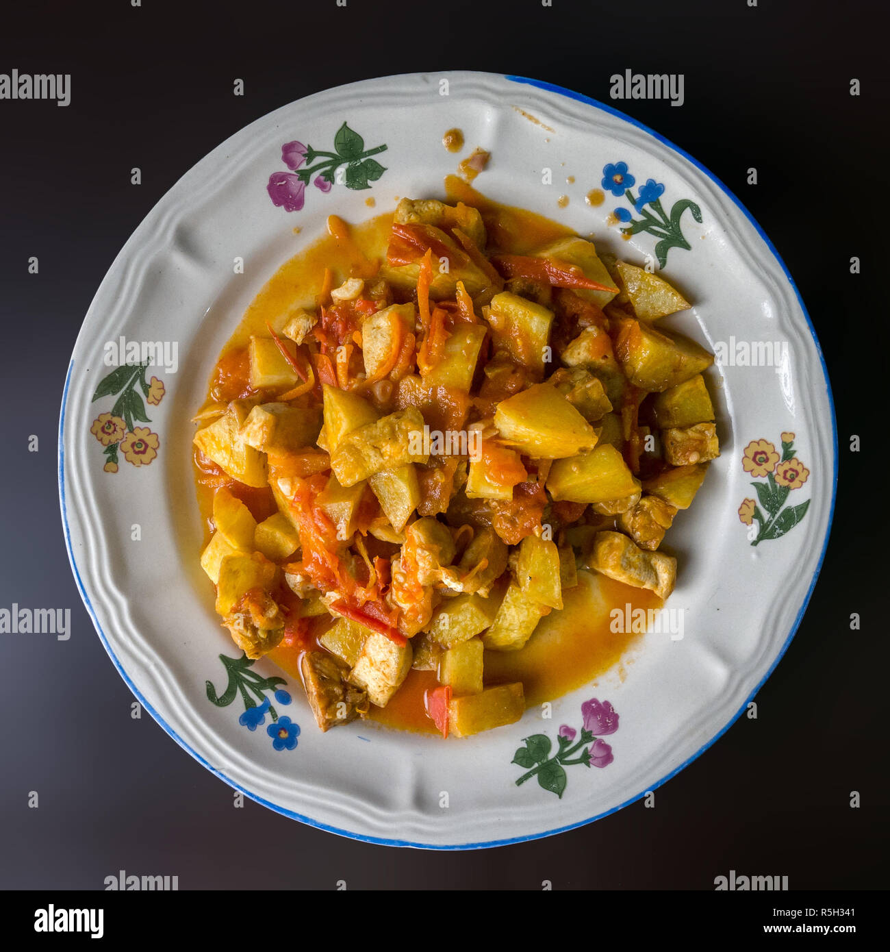 Authentic Indonesian food from family street restaurant. Mixed tofu potato and tempe cooked in tomato and carrot sauce. Delicious Stock Photo