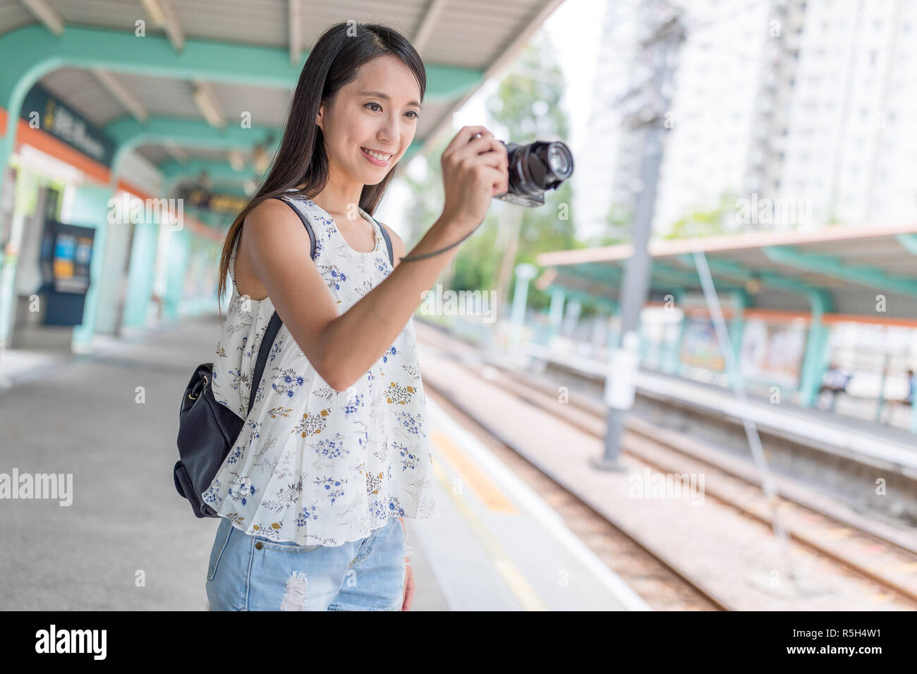 Woman taking photo in Hong Kong light rail station Stock Photo - Alamy