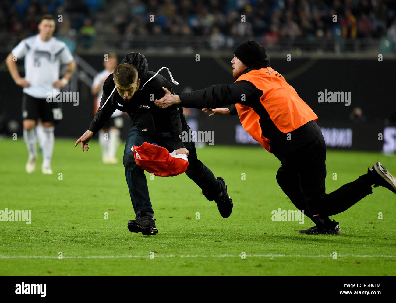 Leipzig, Germany - November 15, 2018. A Russia fan chased by a steward after running onto the pitch during international friendly Germany vs Russia in Stock Photo