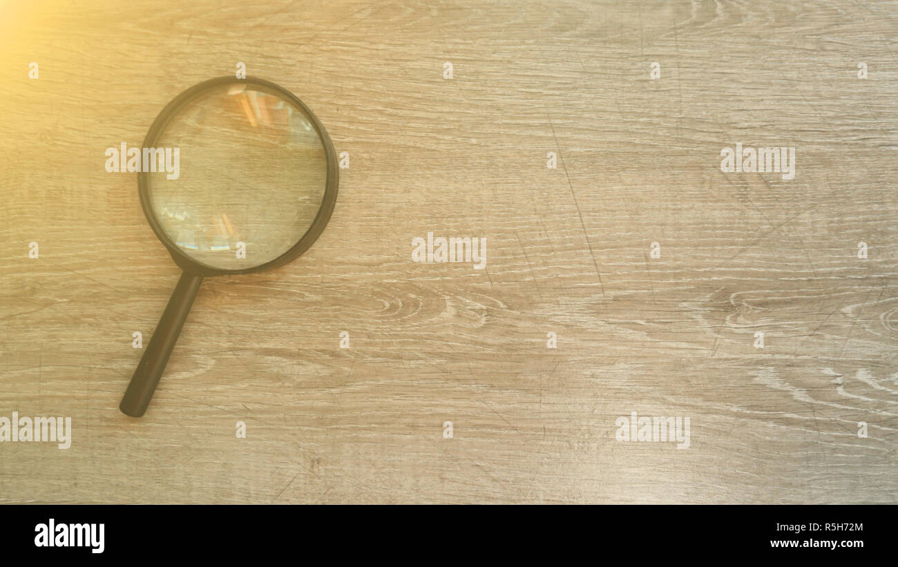 magnifying glass on the grey laminate background. Sun effect Stock