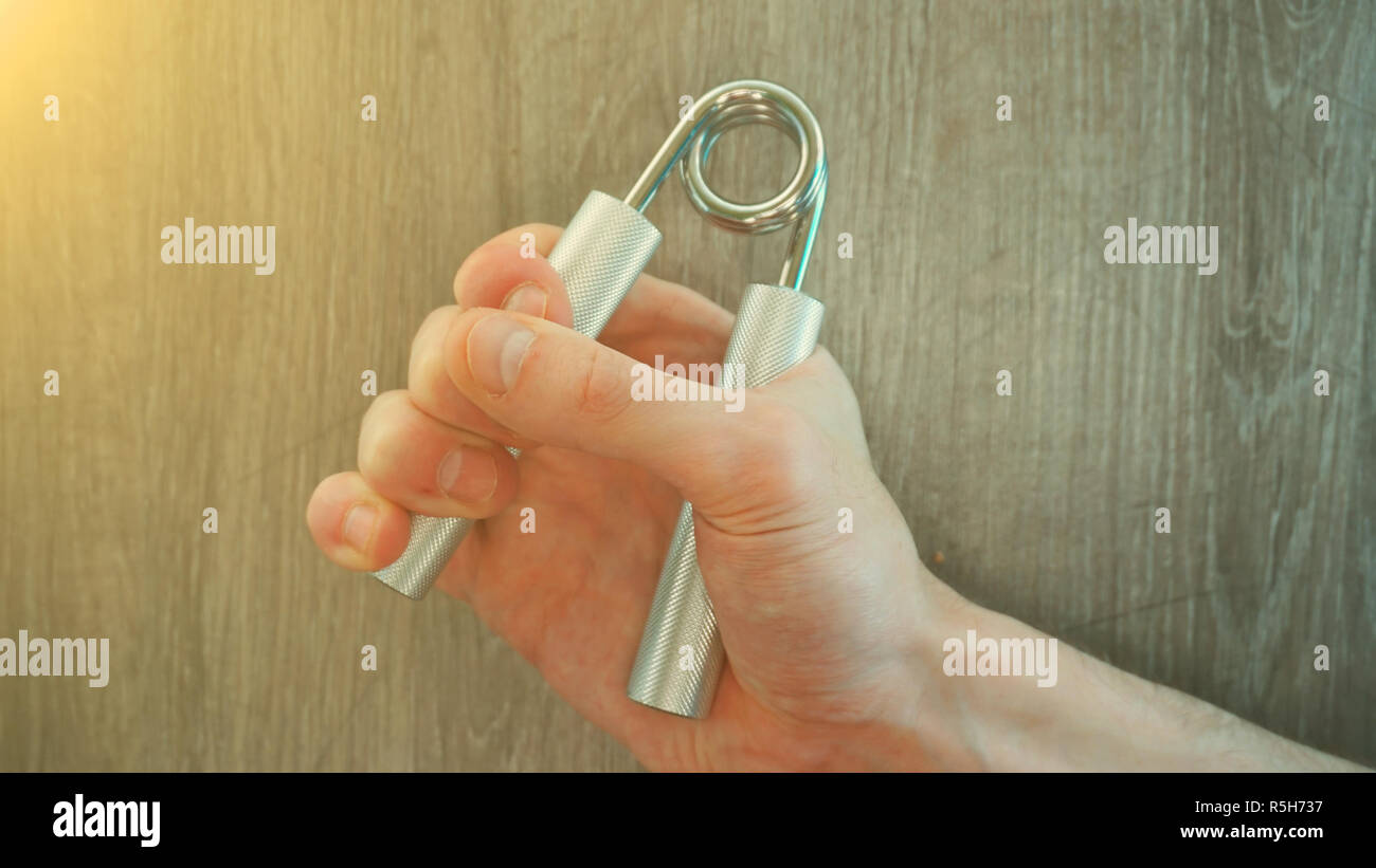 hand expander in the hand of a young athlete. sun effect Stock Photo ...