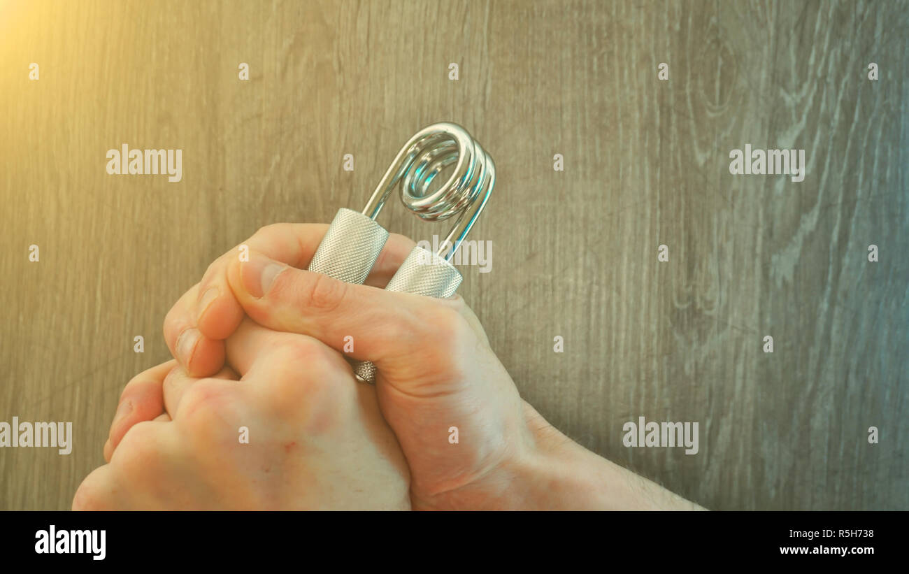 hand expander in the hand of a young athlete. sun effect Stock Photo ...