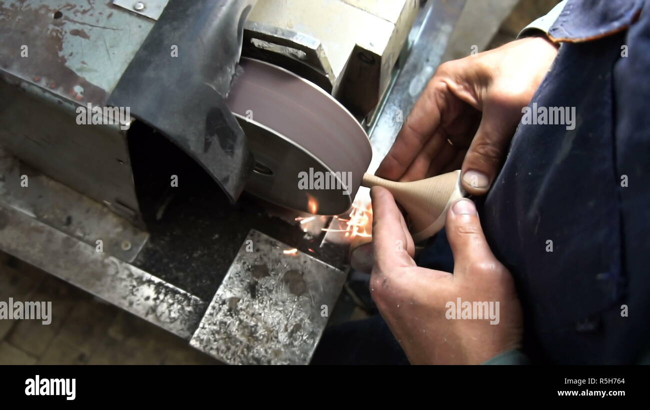 the shoemaker's sharpening metal taps on the machine Stock Photo