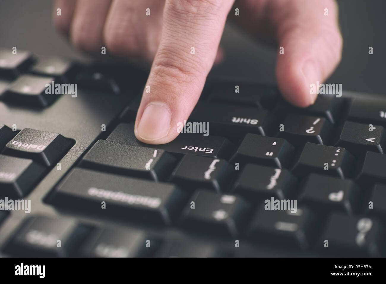 Person typing on a keyboard and pressing Enter key. Close up. Stock Photo