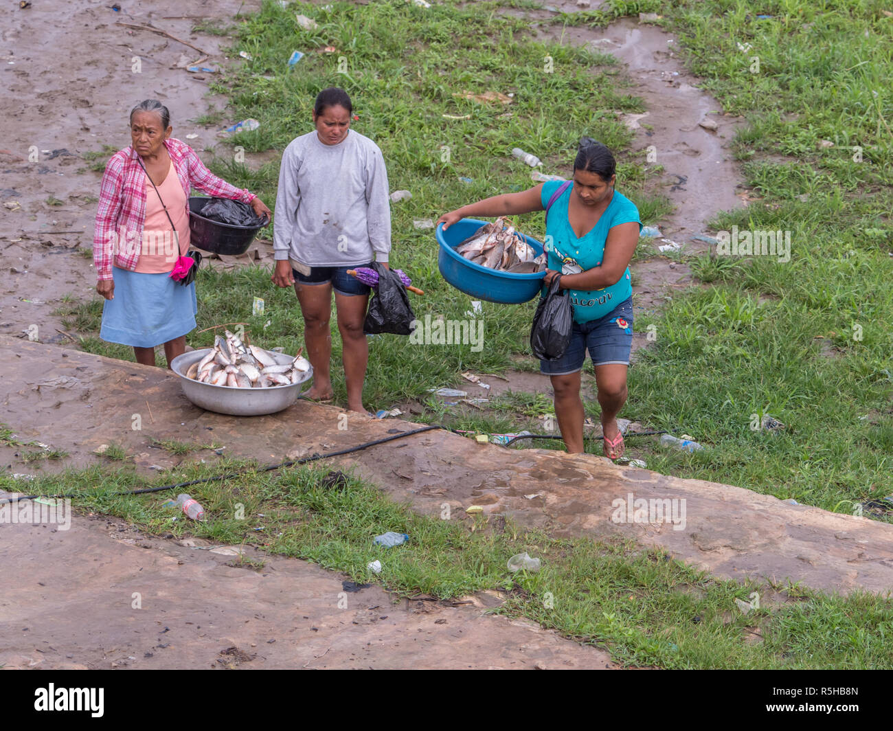 Tabatinga, Brazil - September 15, 2018: Women are selling the fishes during rainy day in the port of Amazon river. Tres Fronteras. Latin America. Amaz Stock Photo