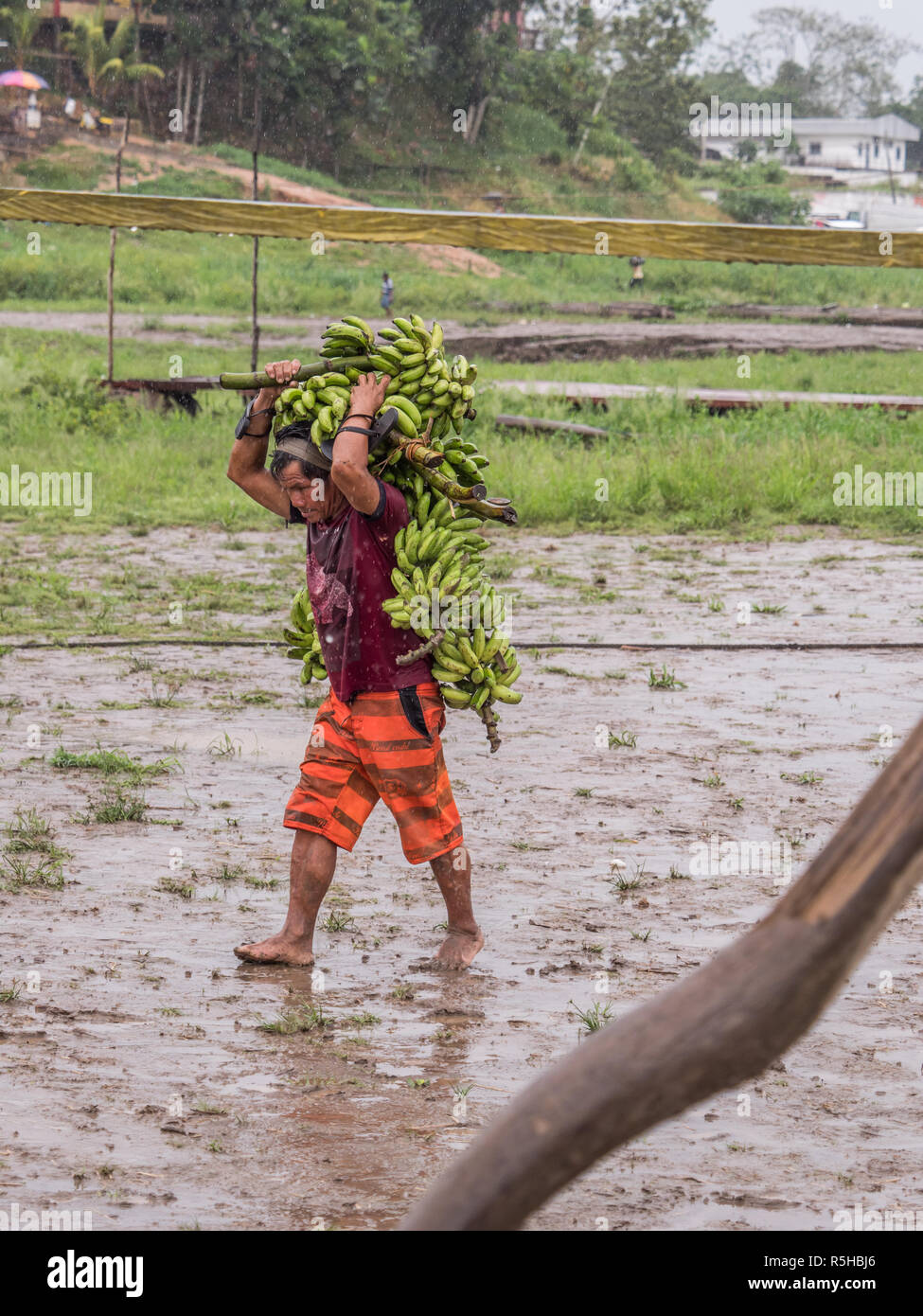 Tabatinga, Brazil - September 15, 2018: Man with the bananas during a rainy day at the port of the Amazon. Tres Fronteras. Latin America. Amazonia. Stock Photo
