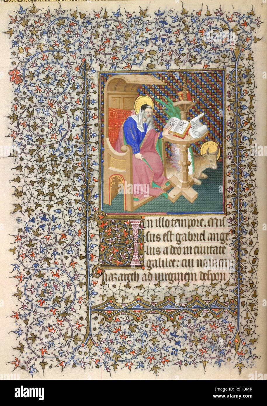 Miniature of Luke as a scribe, with his symbol the ox, with an illuminated initial 'I'(n), and a full foliate border, at the beginning of Luke's Gospel. Book of Hours, Use of Paris. France, Central (Paris); c. 1410 - c. 1420. Source: Yates Thompson 46, f.14v. Language: Latin and French. Stock Photo