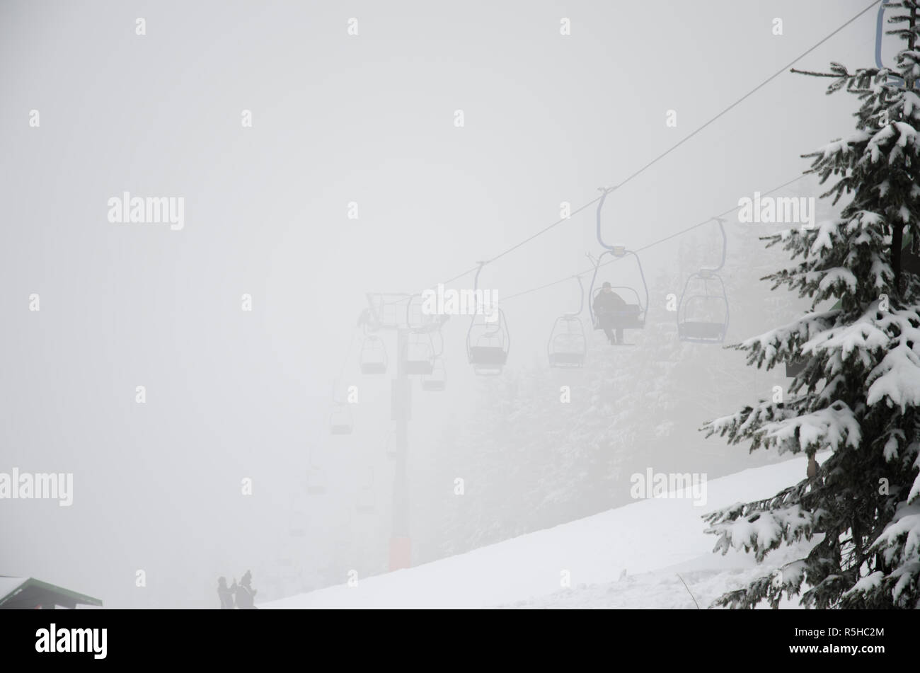 chairlift in winter resort in foggy winter Stock Photo