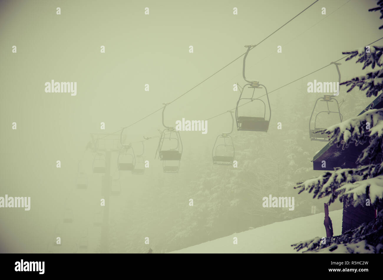 chairlift in winter resort in foggy winter Stock Photo