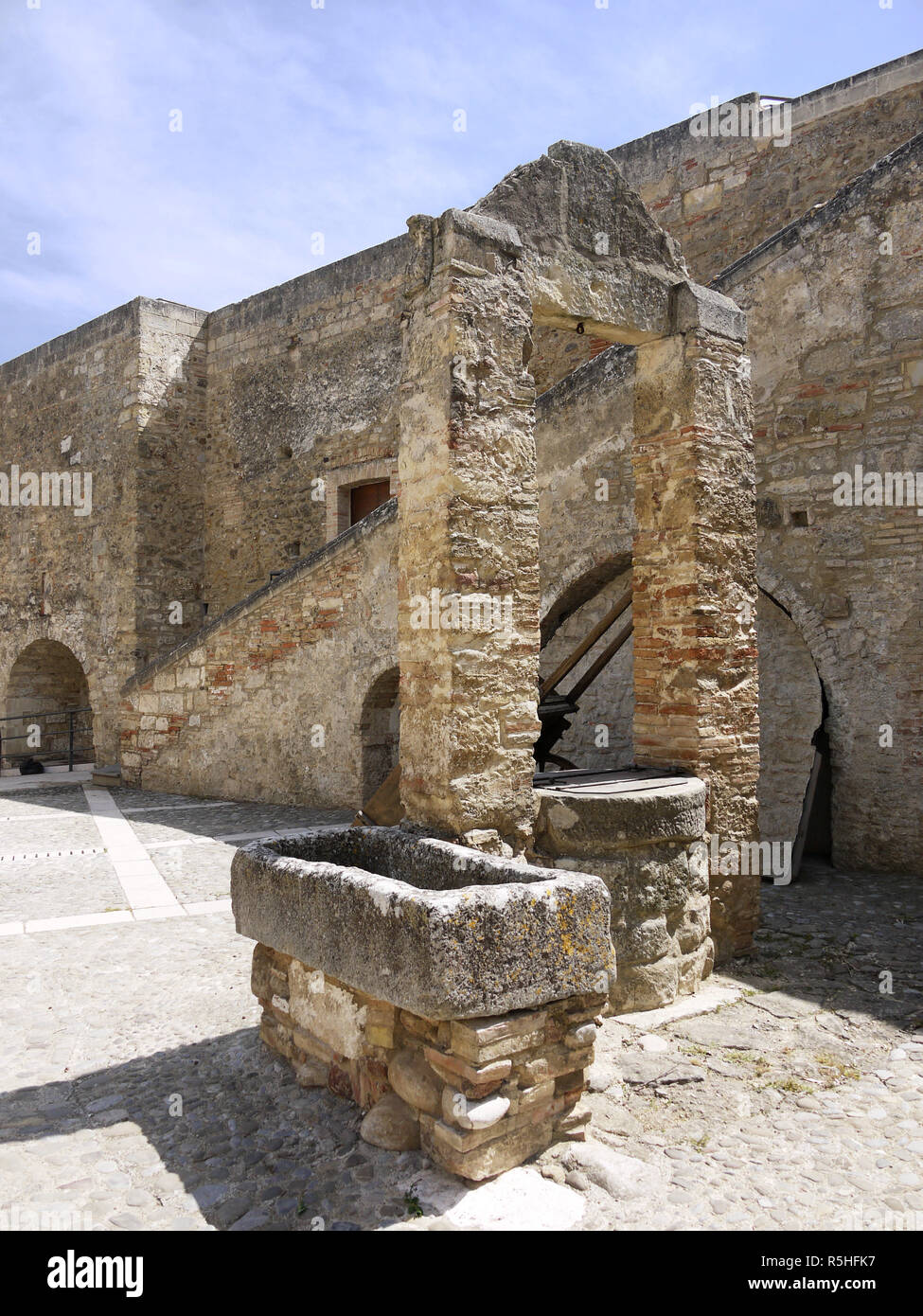 The hilltop town of Miglionico in Basilicata, Southern Italy with the Castello Malconsiglio and a water trough in the courtyard Stock Photo