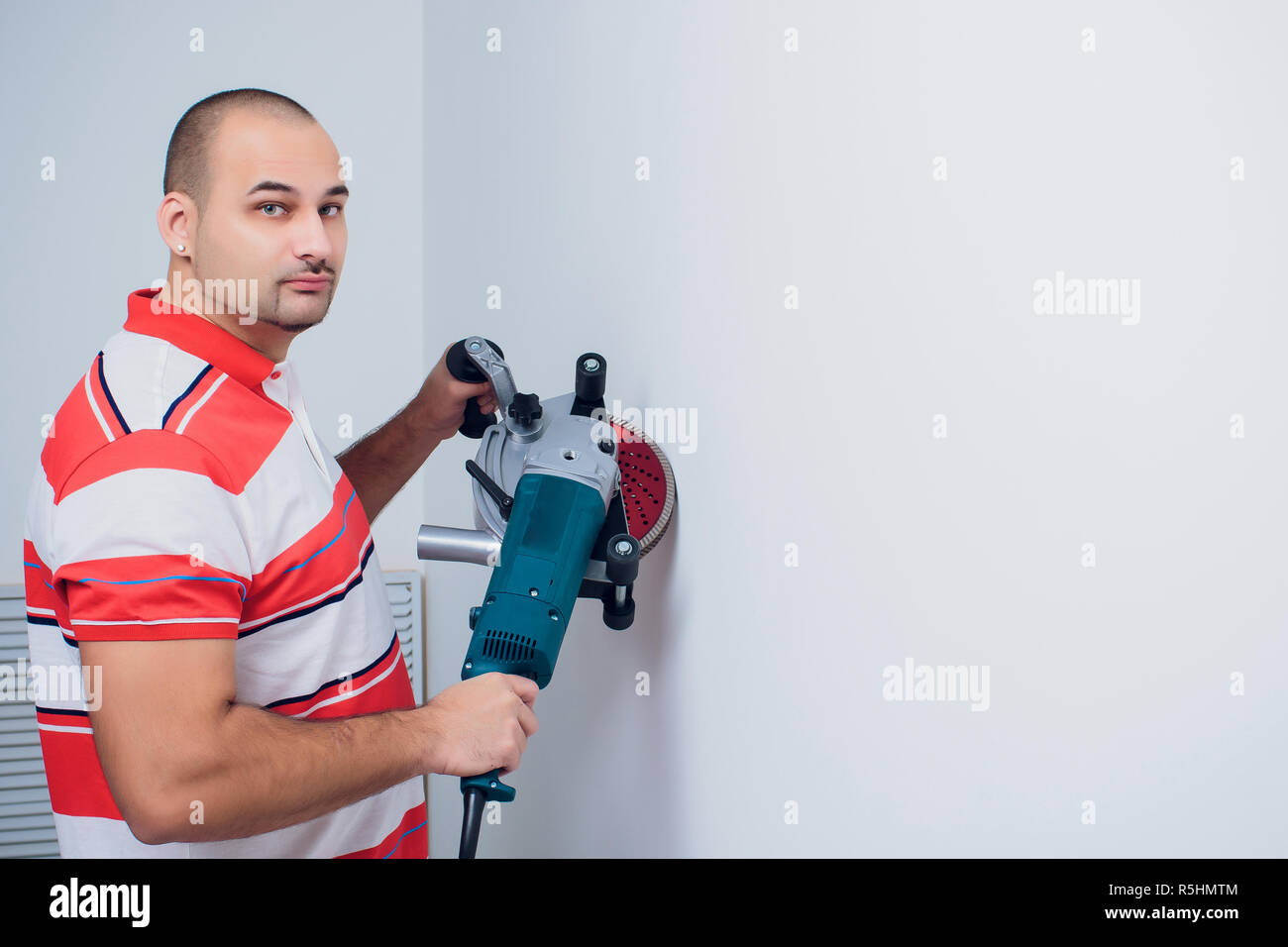 Construction worker with a puncher scream on a white background Stock Photo