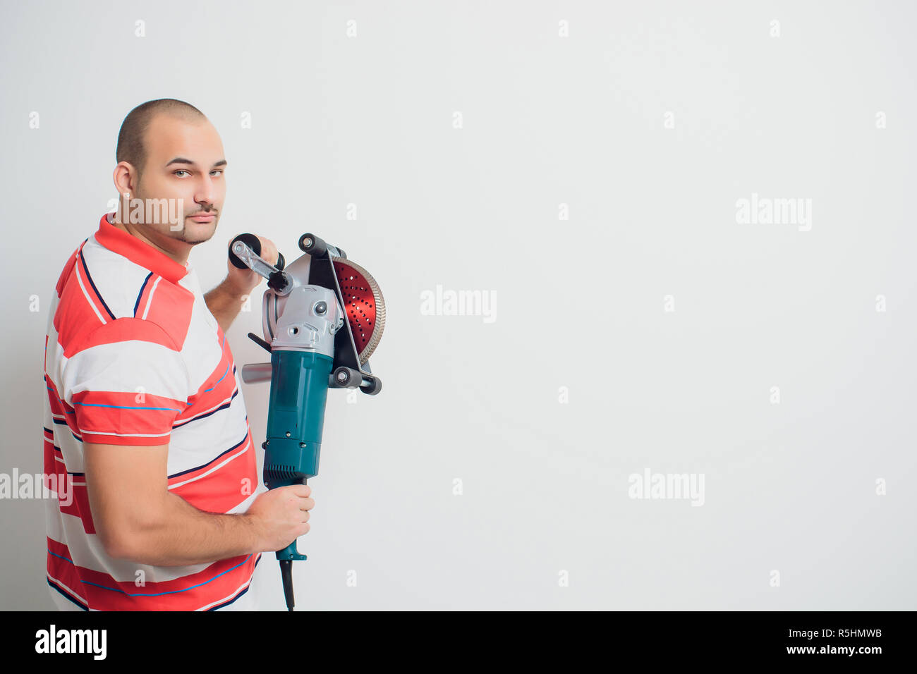 Construction worker with a puncher scream on a white background Stock Photo